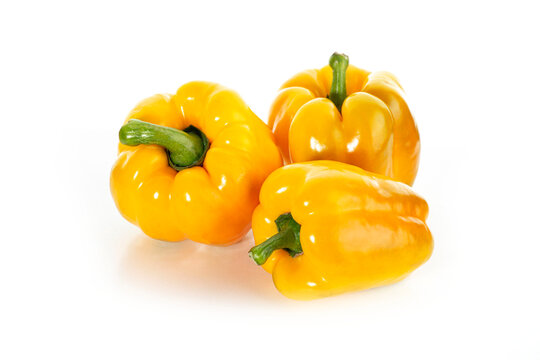 Yellow bell peppers isolated on white background. Fresh whole sweet peppers arranged in cluster. Studio shot