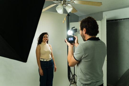Female actress during a casting session, getting her headshot taken by a male photographer in a studio