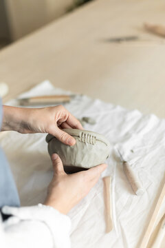 Woman potter meticulously shaping clay in a studio setting