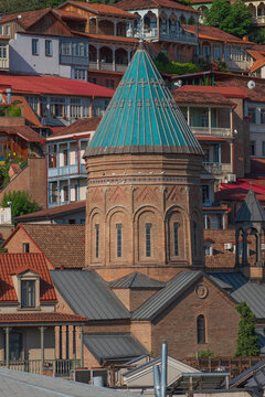 Turquoise dome of Surb Gevorg church against old Tbilisi houses with copy space