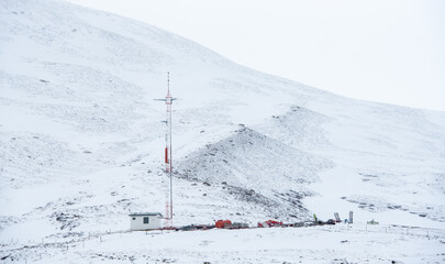 Mobile communications building and communication tower standing on an arctic snowy mountain slope Iceland blizzard weather © Michalis Palis