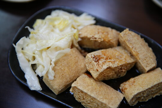 A close up of crispy stinky tofu with pickled cabbage.