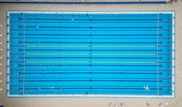Aerial top down view of a water polo match in an outdoor swimming pool