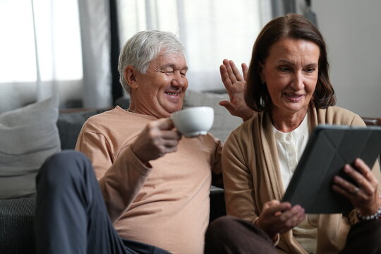 A senior couple enjoy a peaceful morning with coffee in a warm modern home, a cosy lifestyle moment of love and belonging, showing the joy of spending time together at home.
