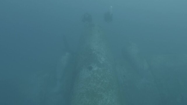 log footage of an airplane wreck underwater scuba divers to explore  metal on ocean floor