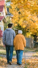 Obraz premium A young person walks hand-in-hand with an elderly individual down a leafy, autumn path, surrounded by vibrant yellow foliage.