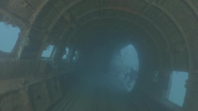 log footage of an airplane wreck underwater scuba divers to explore  metal on ocean floor