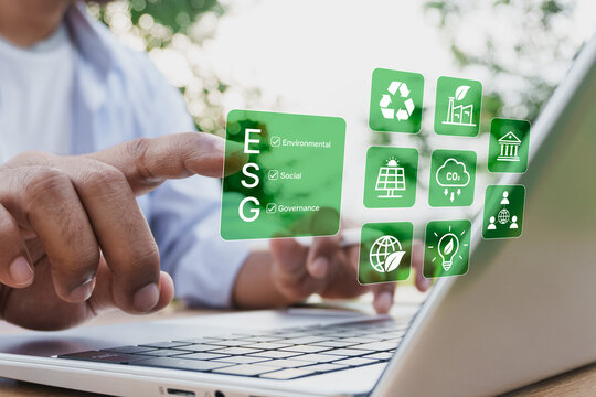 ESG concept, Businessman using digital interface on laptop with environmental, social, and governance icons, sustainability strategy, corporate responsibility, carbon footprint, green business