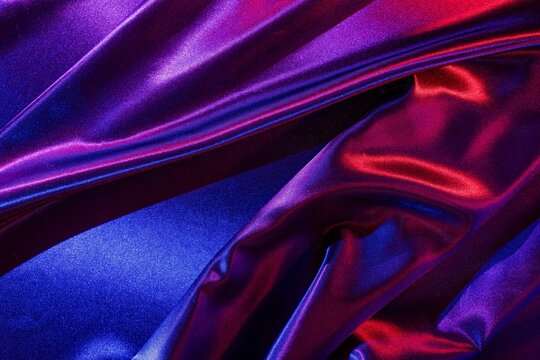 Shiny purple and red fabric. Colorful textile background. Luxurious material pattern.