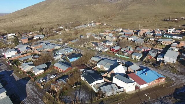 4K aerial drone footage flying over Julia Dufour, a Patagonian mining town in Santa Cruz, Argentina. Scenic urban landscape surrounded by rugged mountains, showcasing the beauty of southern Patagonia.