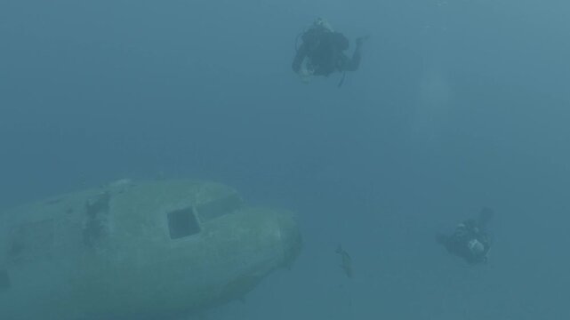 log footage of an airplane wreck underwater scuba divers to explore  metal on ocean floor