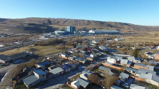 4K aerial drone footage flying over Julia Dufour, a Patagonian megausina in Santa Cruz, Argentina. Scenic urban landscape surrounded by rugged mountains, showcasing the beauty of southern Patagonia.