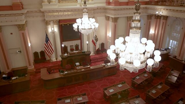 This shows the interior of the Senate Chamber in California State Capitol located in Sacramento during a session with bright lighting.