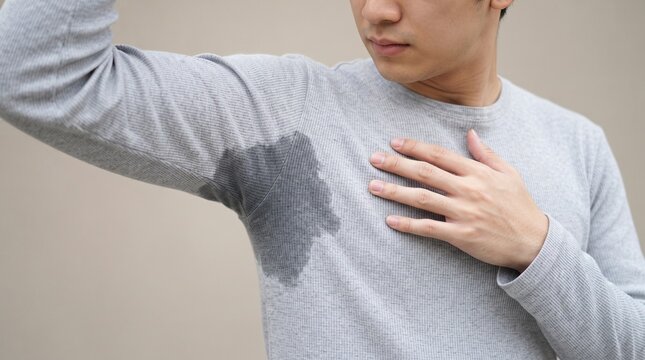 Person with Excessive Underarm Sweating Showing Sweat Stain on Gray T Shirt Close Up