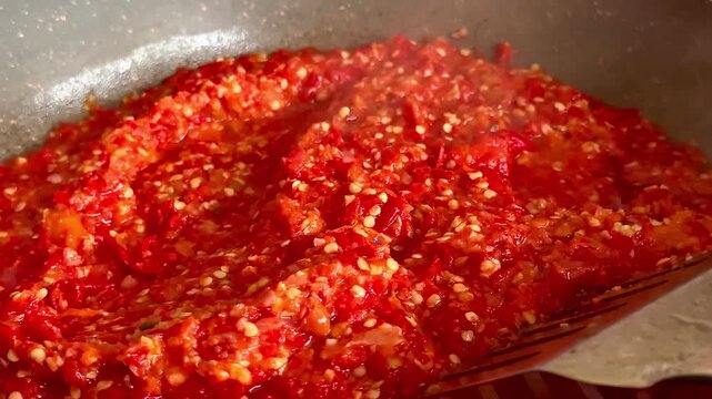 Close up of stirring traditional fried red sambal chili paste