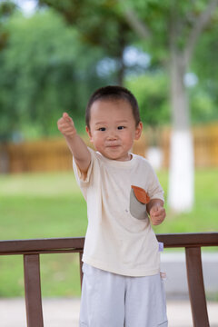 Little boy waving in sunny park