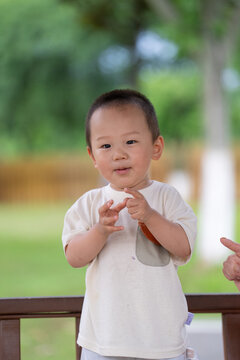 Toddler raising hand while playing outdoors