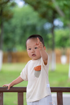 Young boy touching forehead in outdoor park