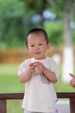 Happy Asian child making gesture in park