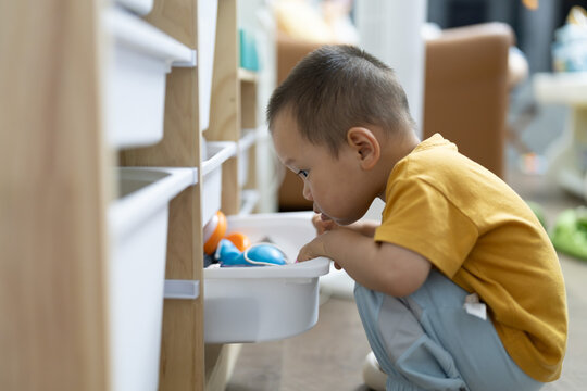 Asian toddler playing with toys at home
