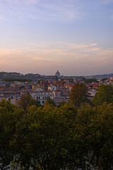 Obraz premium Beautiful vertical sunset view of Rome cityscape with the majestic dome of St Peter's Basilica on the horizon