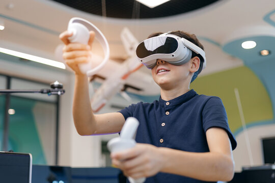 Preteen boy interacting with virtual reality headset in computer AI lab, innovative education