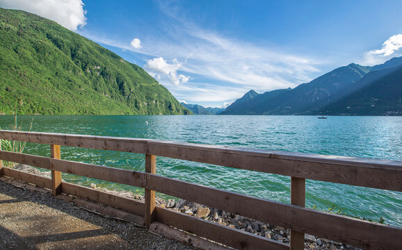 pedestrian bridge with wooden barrier crossing along a nature reserve bordering Idro lake  in mountain, trento country Italy