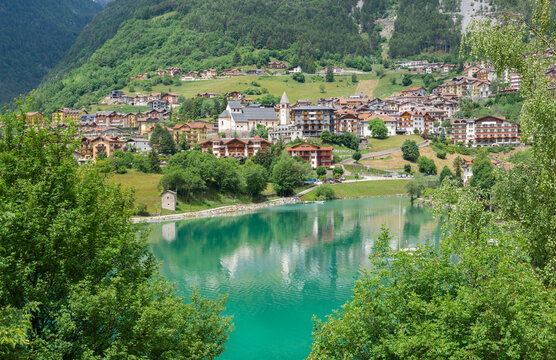 mountain lake of Molveno in Brenta Dolomites in Italy with houses colored in village at the edge of water