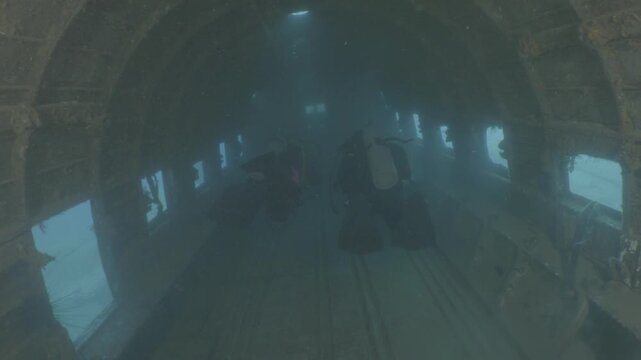 log footage of an airplane wreck underwater scuba divers to explore  metal on ocean floor