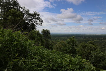 Fototapeta premium On the Nahouri peak, the highest in Burkina Faso at over 400 meters, a tree towers above the horizon, under a sky full of green clouds—a beautiful environment to see and to live in.