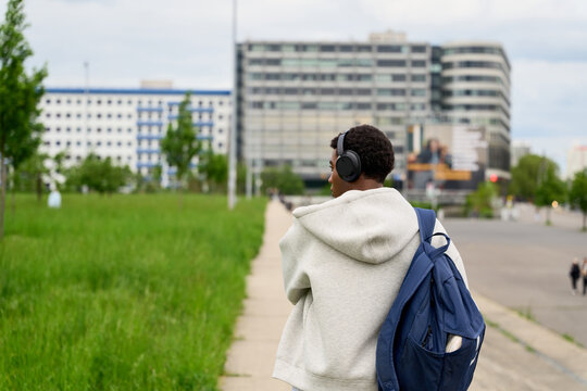 Young Person Walking on a Path in a City Surrounded by Buildings