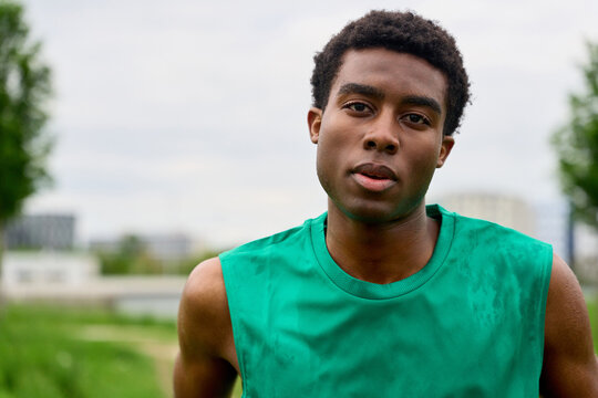 Young Man Stands in Green Shirt Ready for Sports Activity