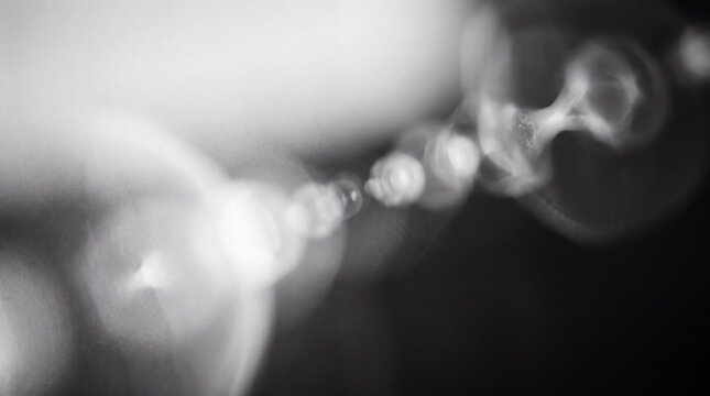 Abstract artistic bokeh background with soft white and grey light orbs, blurred defocused circles creating a dreamy atmosphere for creative design projects
