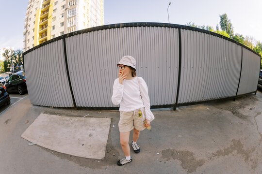 Walking Through the Parking Lot Near a Tall Building in Summer