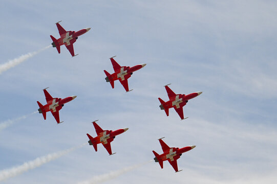 Grenchen, Switzerland - 11.07.2026: Patrouille Suisse aerobatic team performs tight formation flight during air show, leaving white smoke trails.