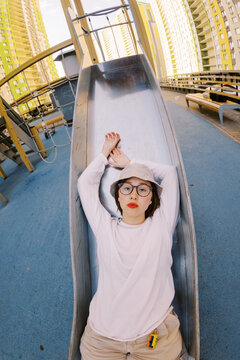 Person Relaxes on a Slide in a City Park During the Day