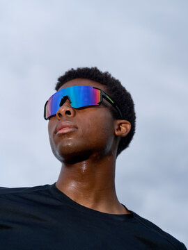 Man Wearing Colorful Sunglasses Under a Cloudy Sky