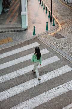 Woman Crossing Zebra Crossing on Quiet City Street