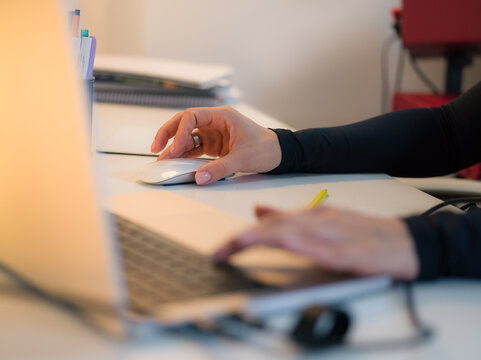 Woman using computer mouse while working at office 