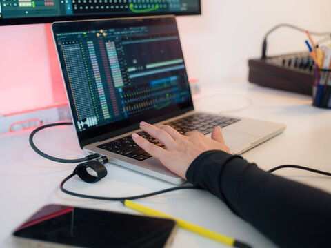 Working on Music Production With a Laptop and Tools at a Desk