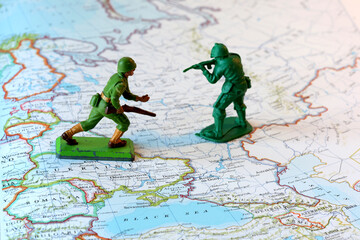 Fototapeta premium Miniature Soldiers Facing Off Over Ukraine on a World Map