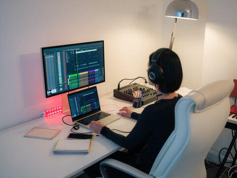 Woman creating electronic music on computer 