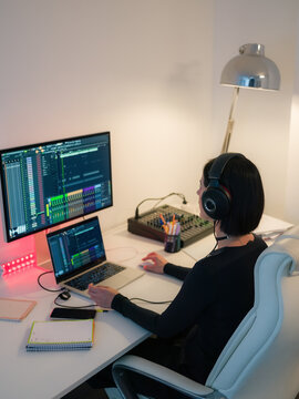 Woman making music on computer at home office 