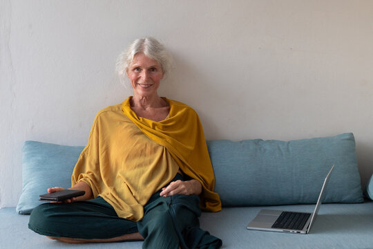 entrepreneur senior woman with laptop, portrait looking at camera
