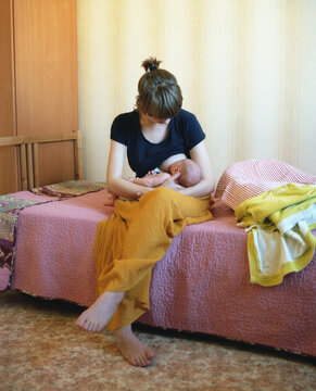Young mother breastfeeds newborn