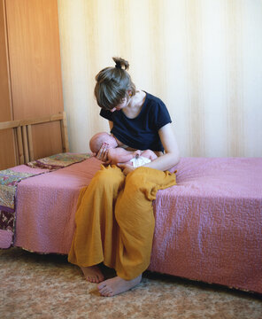 A young mother breastfeeds her baby