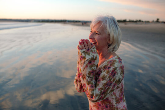 Woman watches sunset at the beach