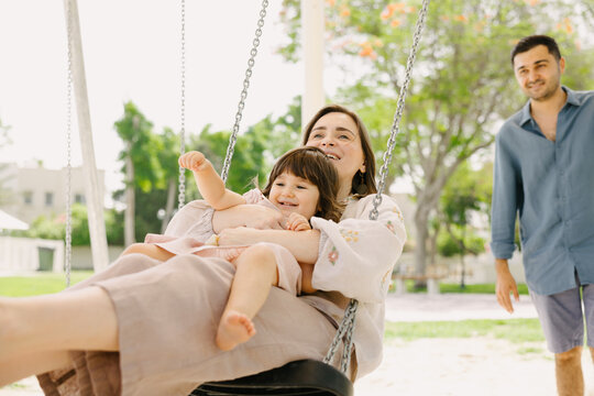 Family in the park on the swing