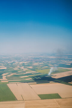 Smoke Rises From Fields in a Rural Area During Daylight Hours