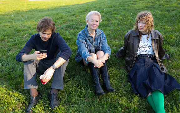 family sitting on the grass in the park